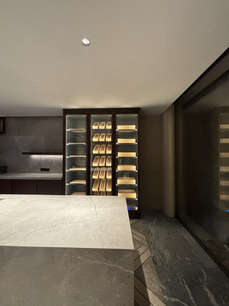 Wet bar with stone counter and integrated backlit refrigerated cabinet